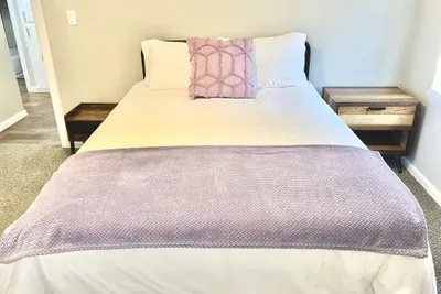 Comfortable queen bed in the second bedroom with cozy linens, perfect for relaxing after exploring Tarleton State or downtown Stephenville