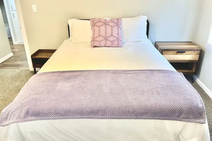 Comfortable queen bed in the second bedroom with cozy linens, perfect for relaxing after exploring Tarleton State or downtown Stephenville