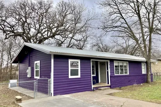 Charming exterior of The Purple House in Stephenville, just 1.2 miles from Tarleton State University, offering the perfect blend of style and convenience