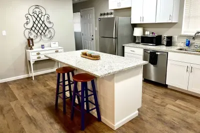 Fully stocked kitchen with modern appliances, granite countertops, and a large island, perfect for preparing meals