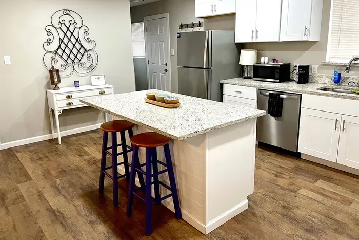 Fully stocked kitchen with modern appliances, granite countertops, and a large island, perfect for preparing meals