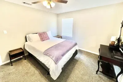 Second bedroom with a queen bed and dedicated work station, perfect for guests needing a quiet space to study or work