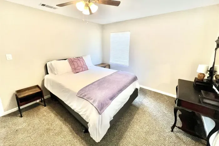 Second bedroom with a queen bed and dedicated work station, perfect for guests needing a quiet space to study or work