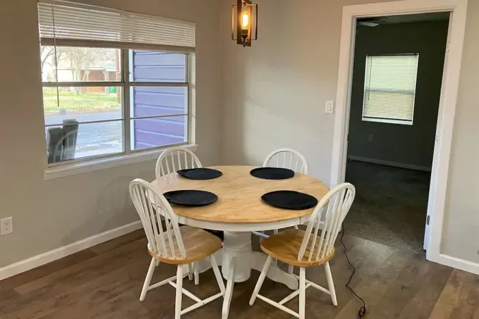 Spacious dining area with a modern table, perfect for enjoying meals or gathering with family and friends during your stay near Tarleton State University in Stephenville.