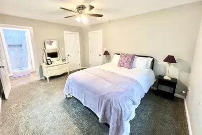Spacious master bedroom featuring a queen bed with brand-new luxury linens and plenty of natural light for a peaceful night’s sleep