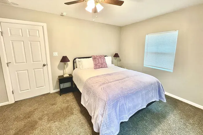 Master bedroom with a queen bed, luxury linens, and direct access to the beautifully remodeled ensuite bathroom