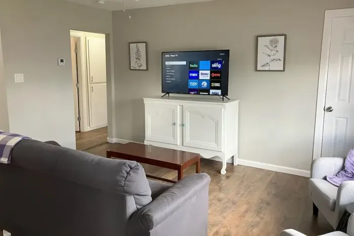 Open living room with a smart TV and comfortable seating, ideal for streaming your favorite shows after a day in Stephenville