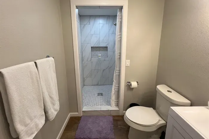 Modern master bathroom featuring a spacious walk-in shower, fresh towels, and stylish finishes