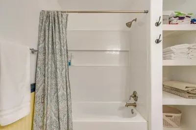 Full bathroom with shower/tub combo, fresh towels, and complimentary shampoo, conditioner, and body wash.