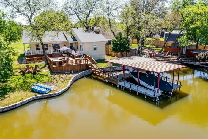 Expansive back deck and private dock with canal access to Lake Granbury — includes paddle boat and space to tie up your boat or jet ski.