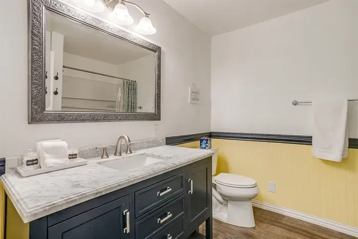 Spacious full bathroom with shower/tub combo and modern vanity — clean, bright, and well stocked.