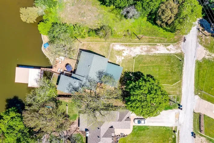 Top-down aerial showcasing private dock, canal frontage, and spacious yard.