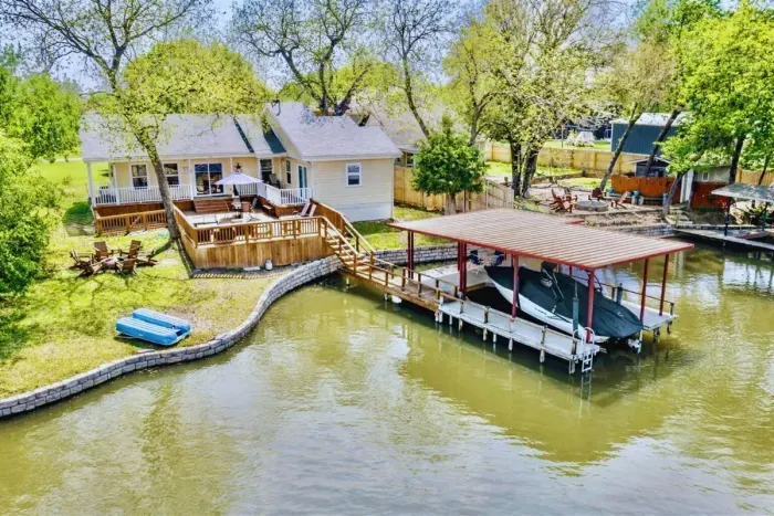 Expansive back deck and private dock with canal access to Lake Granbury — includes paddle boat and space to tie up your boat or jet ski.
