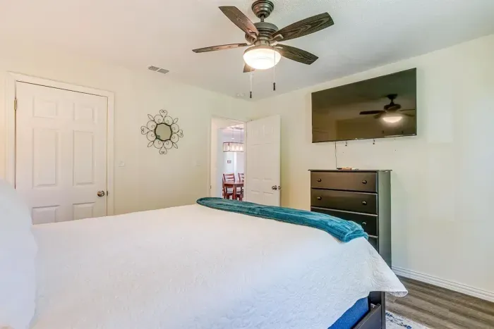 Peaceful primary bedroom featuring queen bed, blackout curtains, and Smart TV for restful lakefront nights.