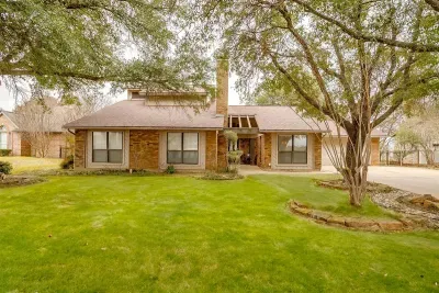 Charming front yard with a welcoming driveway and mature trees, setting the tone for your peaceful getaway