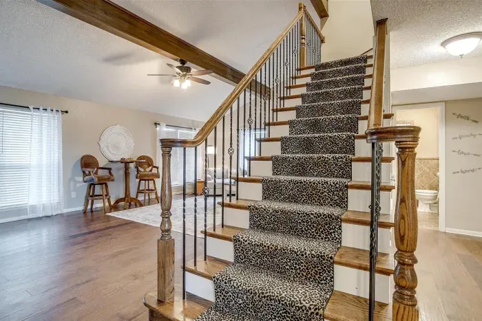 Elegant staircase leading to the bedrooms, with stylish railings and a warm ambiance to welcome you upstairs