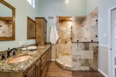 Luxurious bathroom with a modern design, featuring a glass-enclosed shower, high-end fixtures, and ample space to refresh and rejuvenate