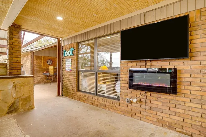 Unwind in the outdoor kitchen featuring a built-in smart TV, fireplace, and ample seating for the ultimate entertainment experience