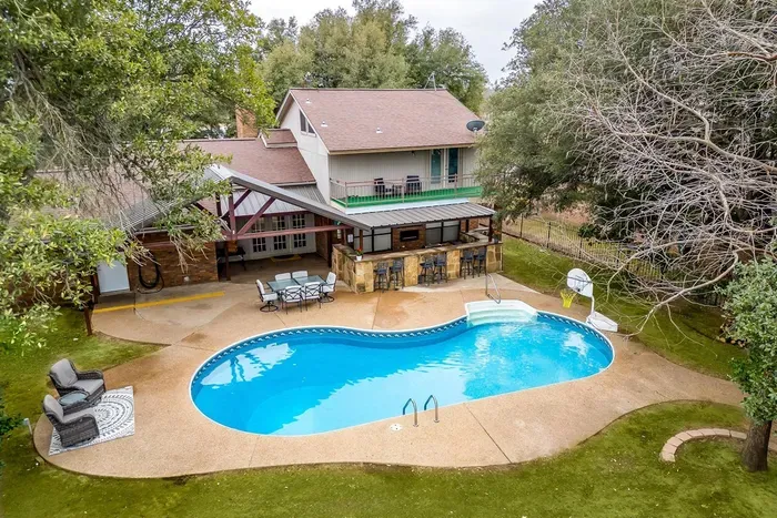 Stunning aerial view showcasing the private pool, spacious patio, and lush surroundings, providing a perfect blend of relaxation and entertainment