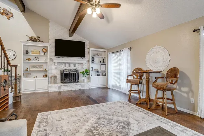 Beautifully designed living area featuring vaulted ceilings, cozy seating, and a large smart TV for a relaxing and inviting atmosphere
