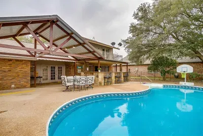 Spacious pool area with a covered patio for lounging, dining, or simply enjoying the serene views of the surrounding golf course