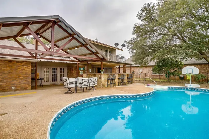 Spacious pool area with a covered patio for lounging, dining, or simply enjoying the serene views of the surrounding golf course