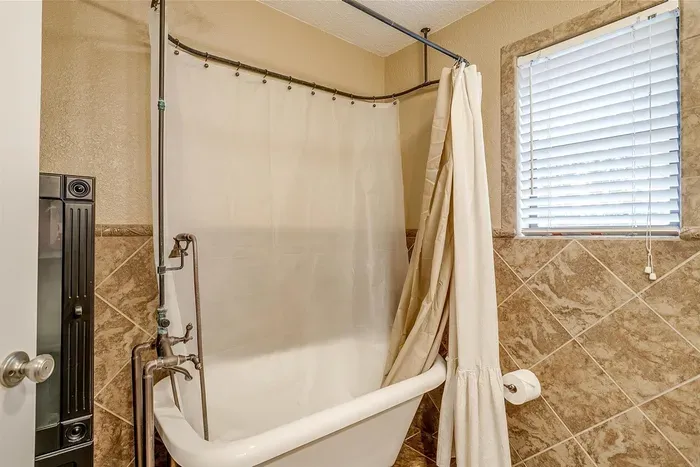 Classic clawfoot tub with a modern shower combination, offering a perfect mix of elegance and functionality for your bathing needs