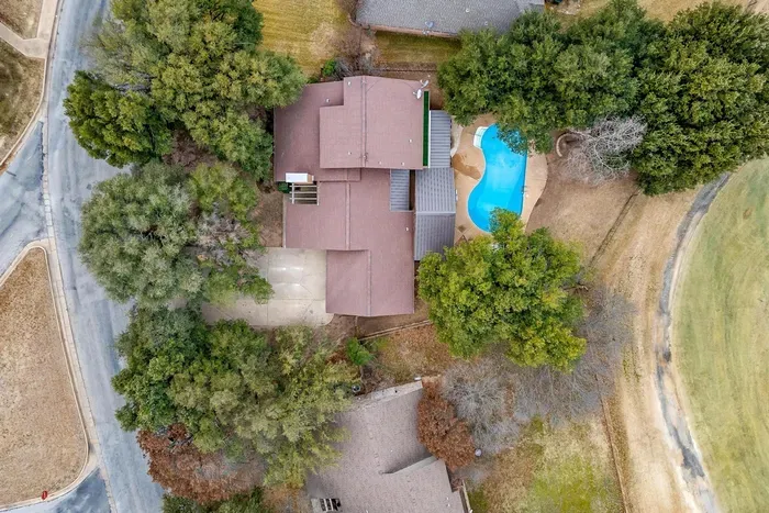 Overhead view of the property, highlighting the large backyard, pool, and proximity to the golf course for a picture-perfect stay