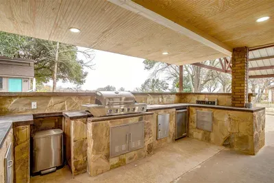 Entertain in style with a fully equipped outdoor kitchen featuring a gas BBQ grill, smart TV, outdoor heater, and ample counter space for al fresco dining