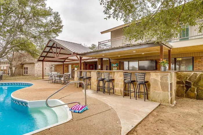 Relax on the back patio with bar seating, complete with a view of the sparkling pool and plenty of space for outdoor dining and entertainment