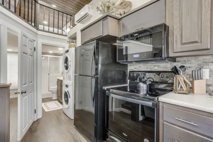 Open kitchen with a loft above and laundry tucked in
