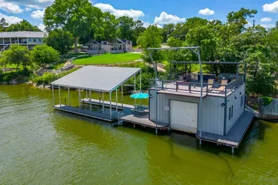 Covered boat dock with a rooftop lounge over the water