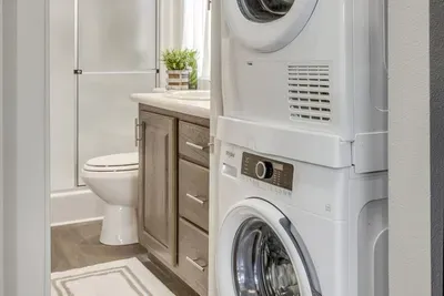 Full bath with a stacked washer and dryer on site