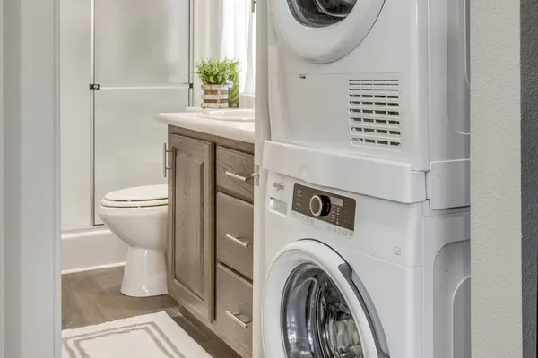 Full bath with a stacked washer and dryer on site