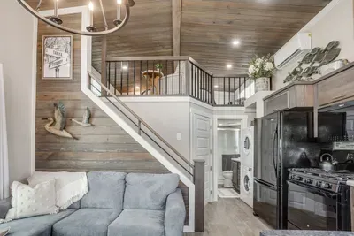 Sofa and full kitchen below a cozy sleeping loft