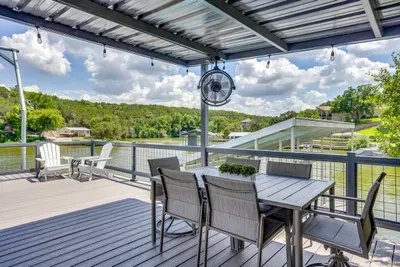 Covered deck dining with a fan and sweeping lake views