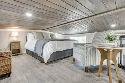 Lofted bedroom retreat under a wood-plank ceiling