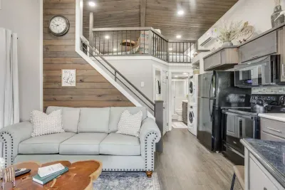 Bright open living space with a full kitchen and loft above