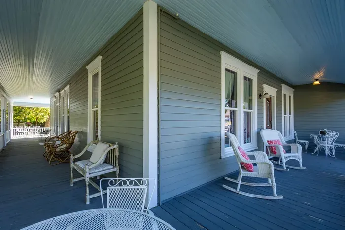 The wrap-around porch invites you to relax and enjoy the outdoors. Perfect for sitting with a drink, chatting with friends, or just soaking in the fresh air, it offers a peaceful retreat that complements the charm of the hotel.