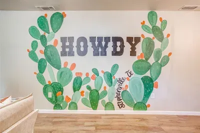 Custom cactus “Howdy” mural adds character and charm to the living room