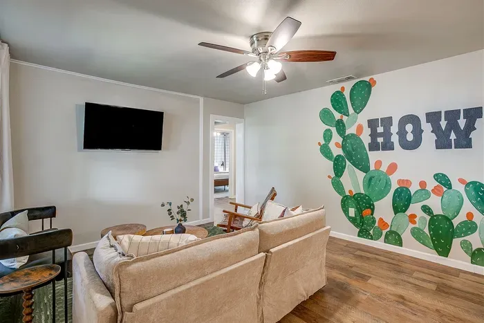 Spacious living room with smart TV and Howdy-themed mural for local flair