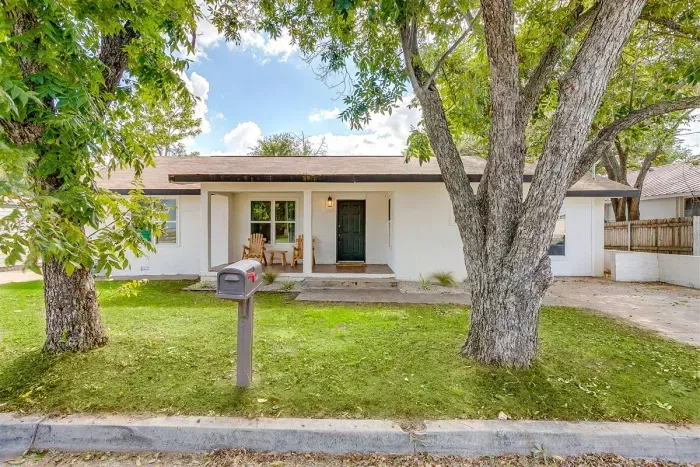 Welcoming front yard with mature trees and covered walkway