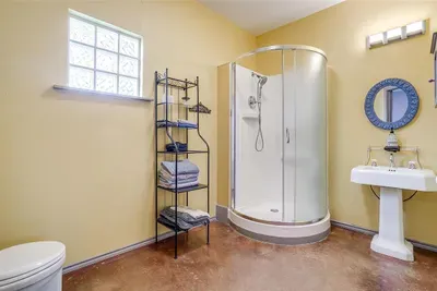 Full bathroom with a modern walk-in shower, bright lighting, and plenty of storage.