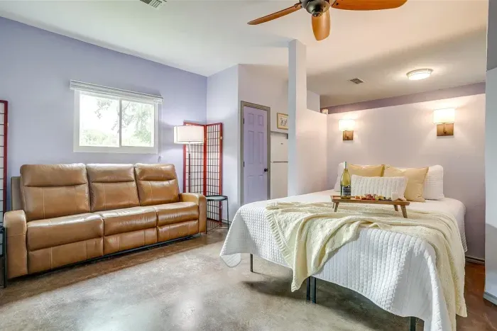 Open studio layout with a comfortable queen bed and recliner couch, perfect for resting after a day exploring downtown or Fossil Rim.