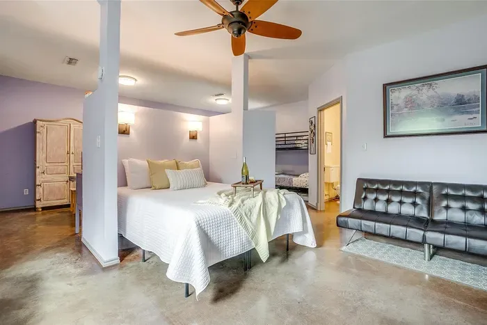 Fold-down black couch adds extra sleeping space near the queen bed — ideal for families or small groups.