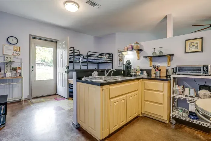 Compact kitchenette includes full-size fridge, microwave, Cuisinart toaster oven, and all essentials for simple meal prep.