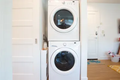 Stackable washer and dryer behind barn door