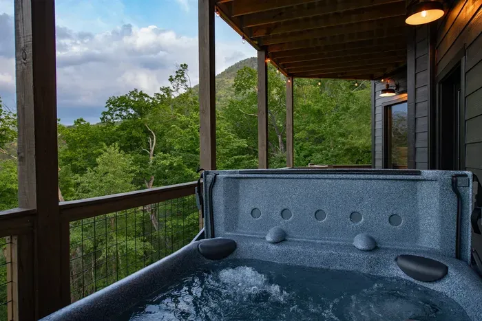 Unwind under the stars in your private hot tub with stunning mountain views