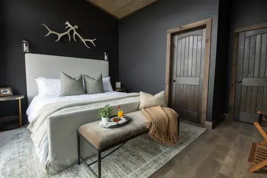 A romantic master suite with mountain views and a private deck featuring a warm outdoor fireplace