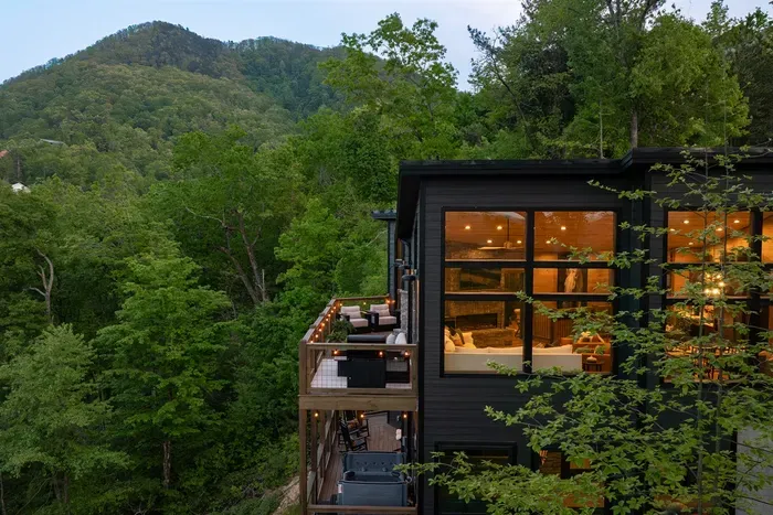 Experience elevated mountain living with expansive decks, cozy outdoor fireplace, and breathtaking forest views